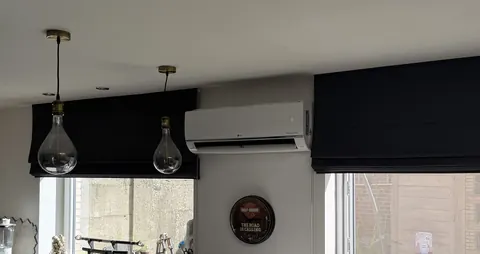 Binnenunit boven de ramen van een eethoek met hanglampen