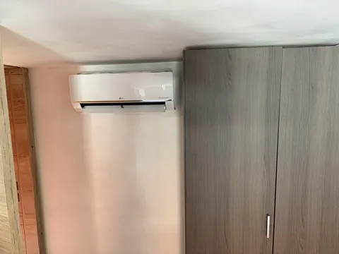 Binnenunit hoog aan de muur naast een kast