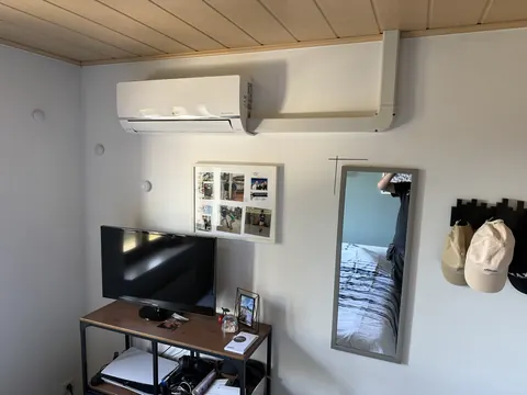Binnenunit in een kamer met een bureau en een tv