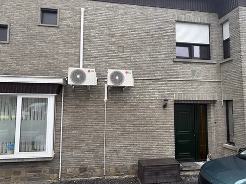 Twee buitenunits naast elkaar aan een bakstenen gevel