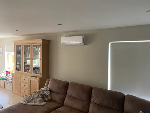 Binnenunit in een woonkamer met een bruine zetel