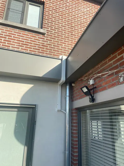 Buitenunit aan een gevel naast het raam