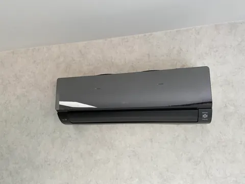 Zwarte binnenunit aan een grijze muur