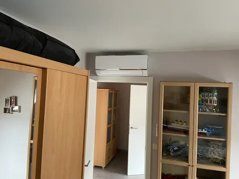 Binnenunit in een slaapkamer boven een houten kast