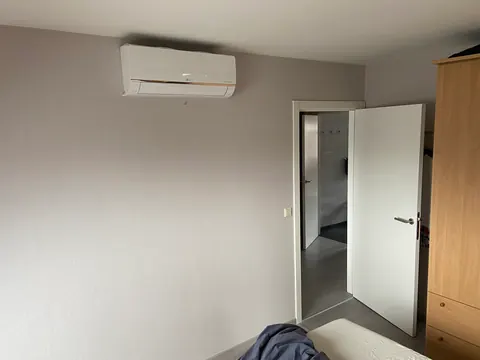 Binnenunit in een lichte kamer naast de deur
