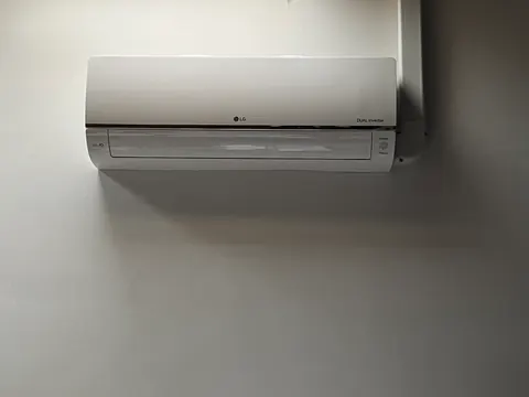 Binnenunit van dichtbij aan een grijze muur