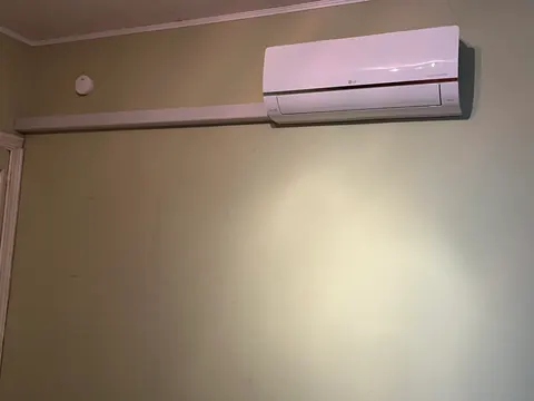 Binnenunit van dichtbij aan een lichte muur